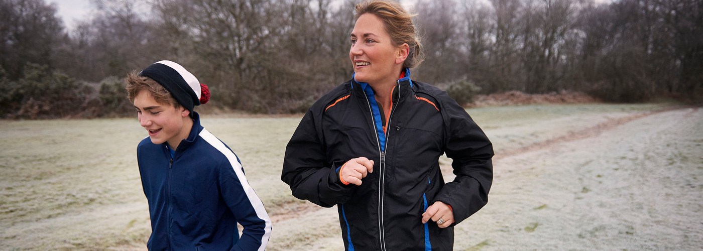 A mum and son jogging outside in winter time 