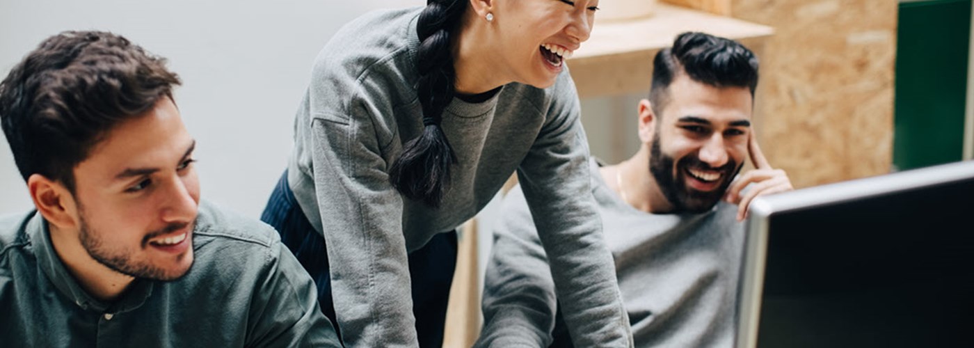 Group of young employees looking at work together