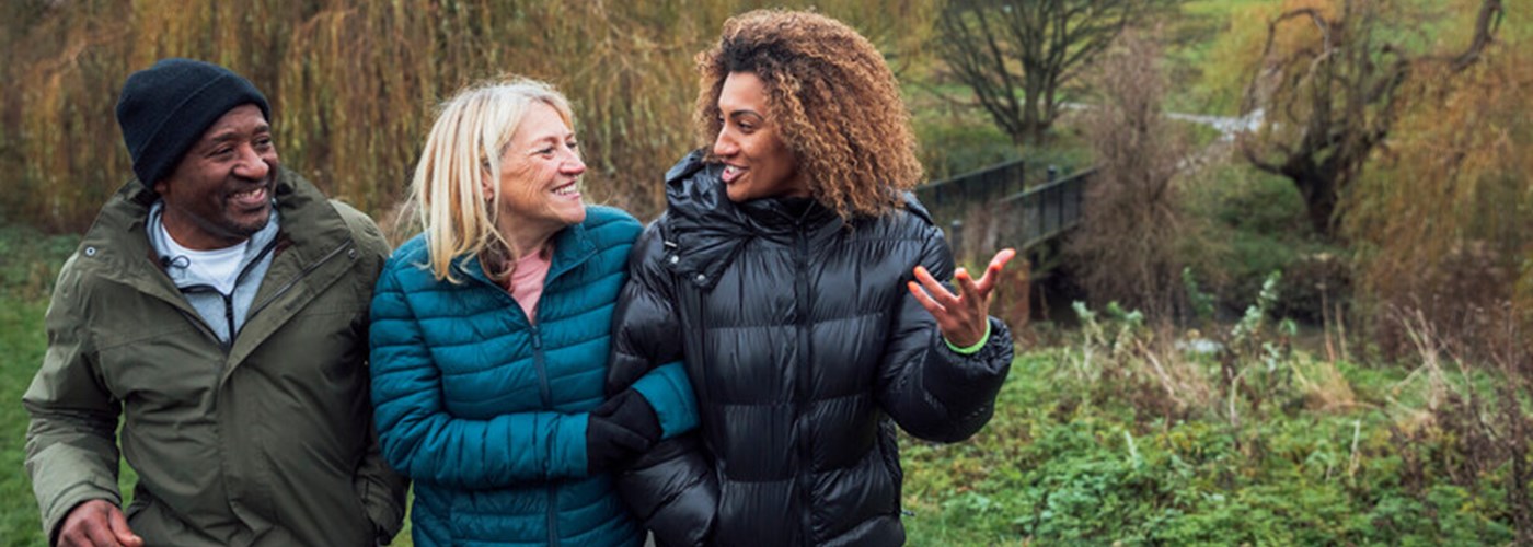 A family talking while taking a riverside walk