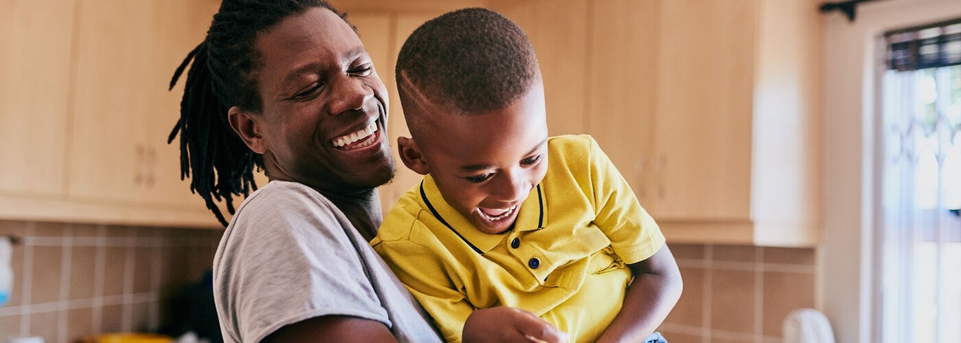Father and young son playing in kitchen