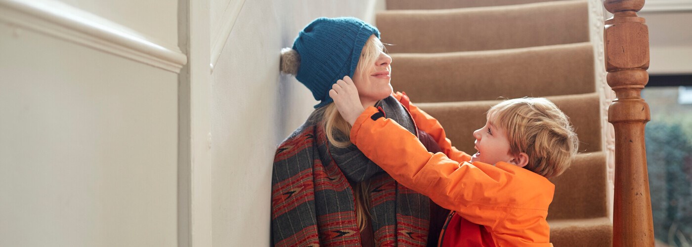 Mother and son getting dressed warm in winter