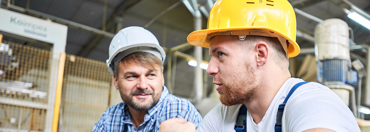 A middle-aged woman with short brown hair sat on the sofa holding a remote, looking concerned. 