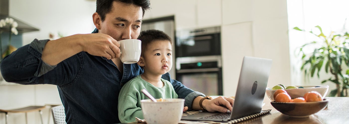 Father at computer with son on his knee