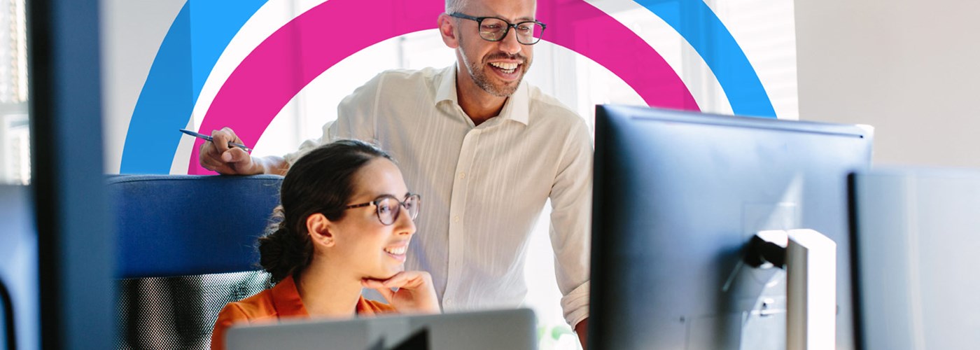 Man and woman in the office both looking at her computer screen