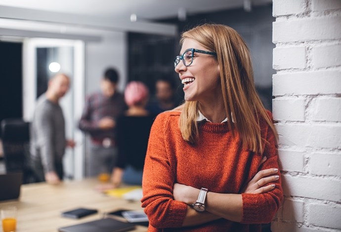 Lady smiling against a wall