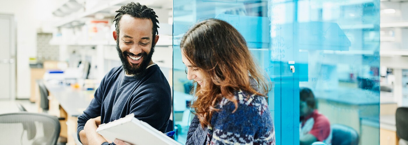 Two colleagues casually discussing a project in an office