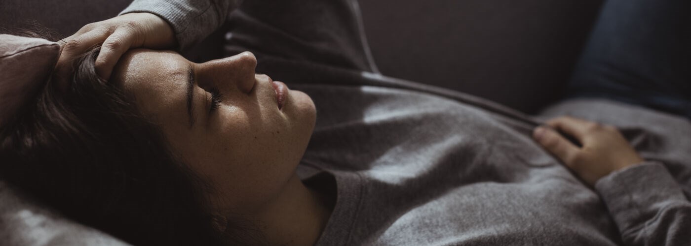 Distraught tired lady, lying down on a sofa