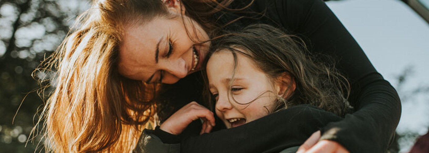Woman with short blonde hair on the sofa with a mug and magazine, resting on a pillow 
