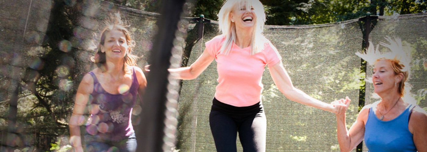 Three women energetically jumping on a trampoline