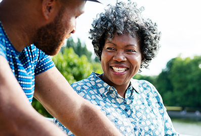 Elderly mother and adult son smiling, chatting